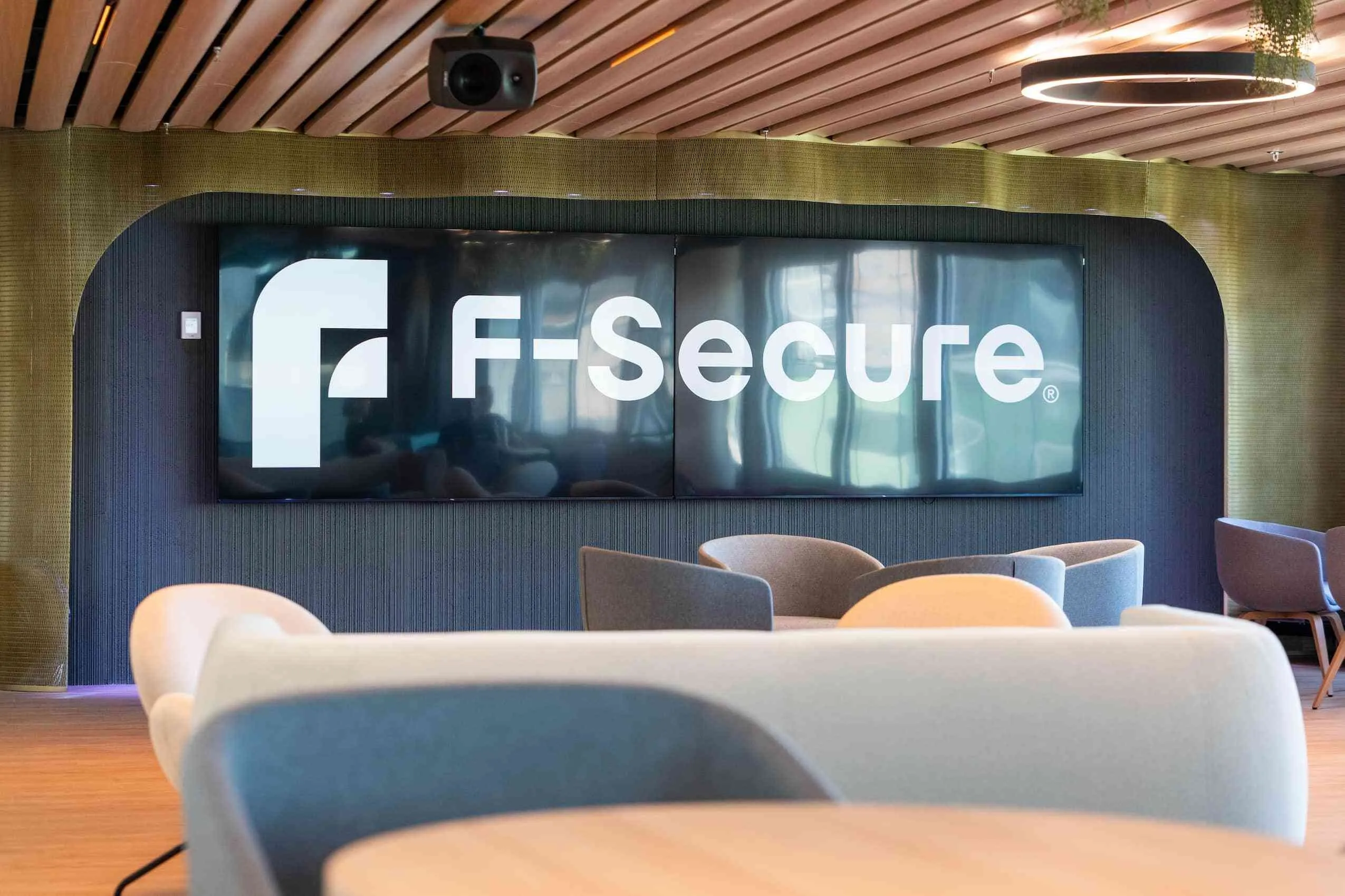 A seating area in the F-Secure office, the company logo on screens behind it